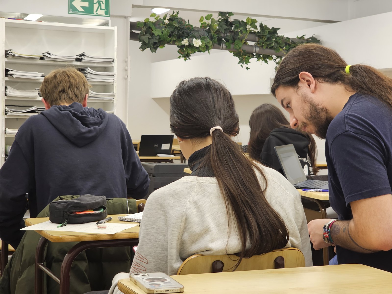 Profesor resolviendo dudas en clase